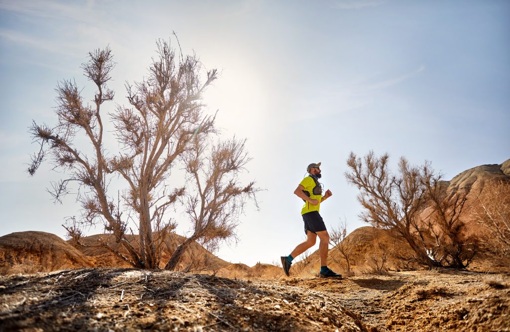 Person running in desert terrain.